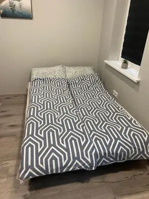 a bed with a blanket on top of it in a room at A&D Apartament in Kaunas