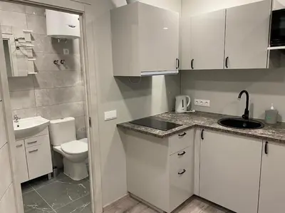 a white bathroom with a toilet and a sink at A&D Apartament in Kaunas