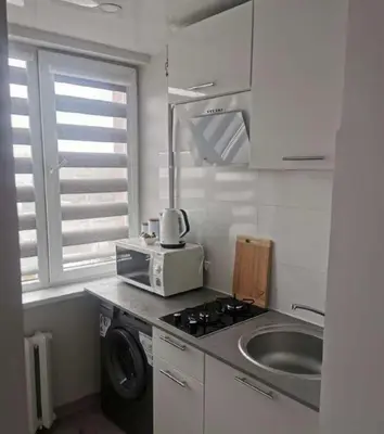 a kitchen with a sink and a microwave at Lauros & R apartamentai in Panevėžys