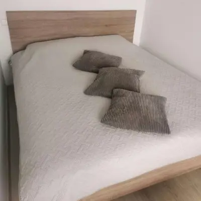 a bed with three brown pillows on it at Lauros & R apartamentai in Panevėžys