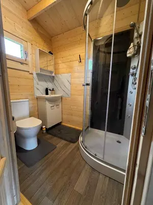 a small bathroom with a shower and a toilet at Poilsio Pieva in Ąžuolų Būda