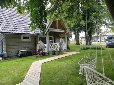 a small house with a porch and a yard at Namelis su pirtimi in Kaunas