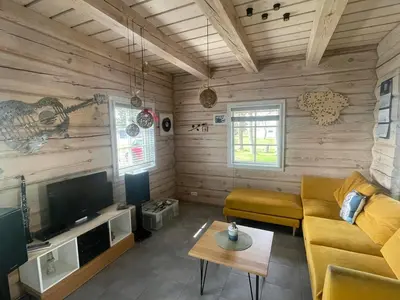 a living room with a couch and a tv at Namelis su pirtimi in Kaunas