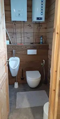 a bathroom with a toilet and a sink and a tv at Namelis su pirtimi in Kaunas