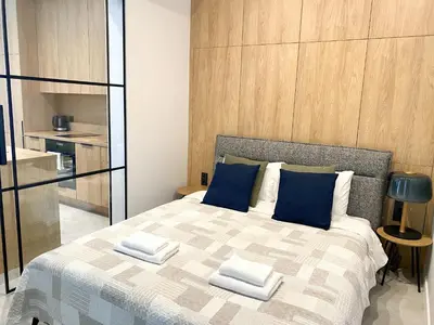 a bedroom with a large bed with blue pillows at White Lotus Apartment 13 by Reside Baltic in Vilnius
