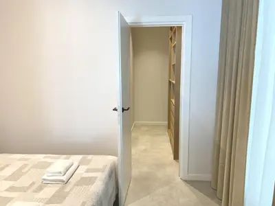 a white bedroom with a bed and a closet at White Lotus Apartment 13 by Reside Baltic in Vilnius