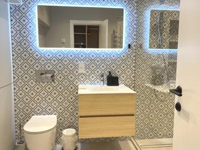 a bathroom with a white toilet and a mirror at White Lotus Apartment 13 by Reside Baltic in Vilnius