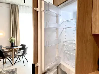 a room with an empty refrigerator with a table at White Lotus Apartment 13 by Reside Baltic in Vilnius