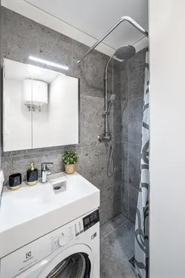 a washing machine in a bathroom with a shower at Central Cozy 1Bedroom Apartment with Sofa Bed - Sleeps 4 in Vilnius