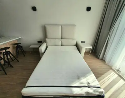a white bed in a room with chairs and a window at Cozy flat 911 in Vilnius