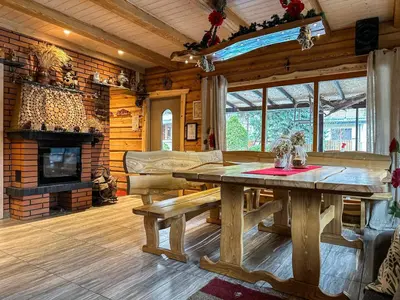 a dining room with a table and a fireplace at Pirtelė Rykštelė in Karmėlava
