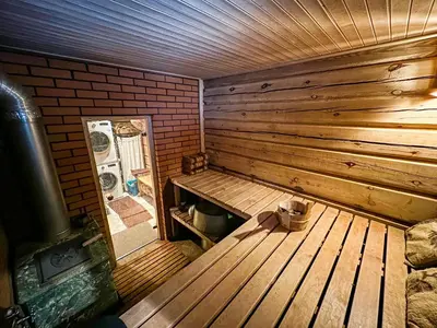 a wooden sauna with a wooden bench in a room at Pirtelė Rykštelė in Karmėlava