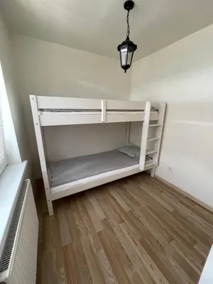 a white shelf in a room with a fan at JZ apartamentai in Kelmė