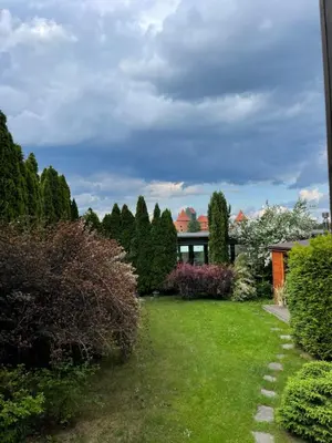 a garden with green grass and trees and a building at Trakai Castle View Villa55 in Trakai