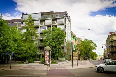 a person crossing a street in front of a building at Luxury Apartments with Large Terrace in City Center in Vilnius