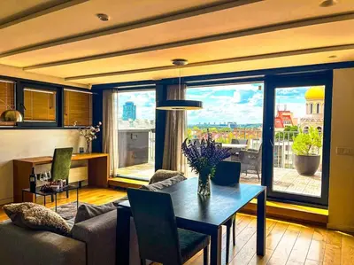 a living room with a couch and a table with flowers at Luxury Apartments with Large Terrace in City Center in Vilnius
