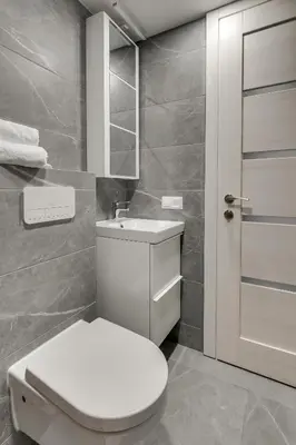 a bathroom with a white toilet and a sink at Uptown Lofts in Vilnius
