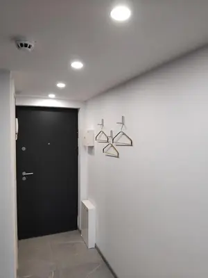 a hallway with a black door and a wall at Uptown Lofts in Vilnius