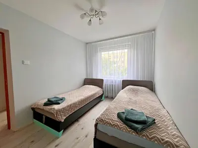 two beds in a room with a window at Tytuvėnai-trumpalaikė nuoma in Tytuvėnai