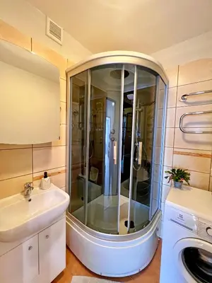 a shower in a bathroom with a sink and a mirror at Tytuvėnai-trumpalaikė nuoma in Tytuvėnai