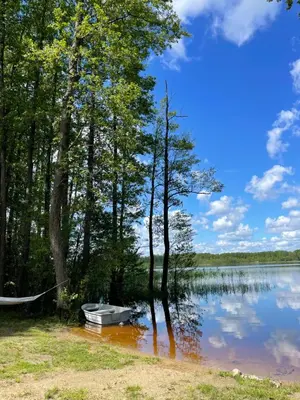 a boat sitting on the shore of a lake at Jack namai 1 in Puodžiai