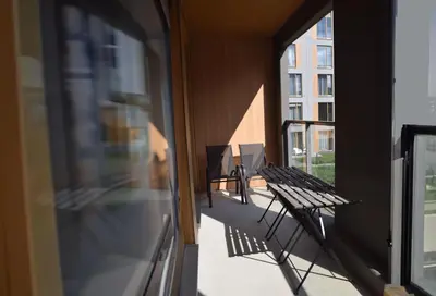 an empty balcony with chairs and a building at Cozy apartment located near to Paupys in Vilnius