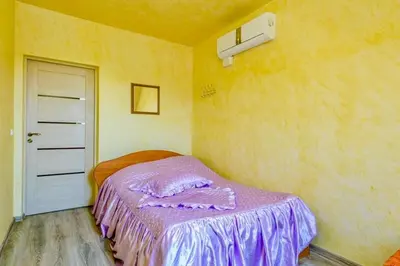 a bedroom with a bed with a purple blanket on it at Tytuvos upelio Krantinė in Tytuvėnai