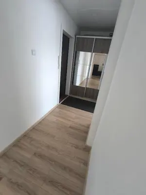 an empty room with white walls and wood floors at Sky View in Marijampolė