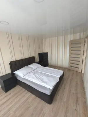 a bedroom with a large bed with white sheets at Sky View in Marijampolė