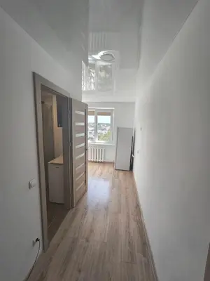 an empty white room with a door and a wooden floor at Sky View in Marijampolė