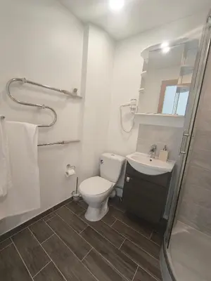 a bathroom with a toilet and a sink and a shower at Sky View in Marijampolė