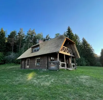 an old log cabin in a field of grass at Poilsiadienis in Aukštadvaris