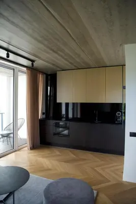 a kitchen with white cabinets and a wooden floor at Ralio apartamentai in Vilnius