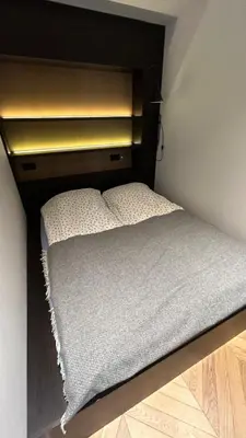 a small bed in a small room with at Ralio apartamentai in Vilnius