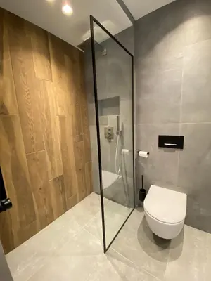 a bathroom with a toilet and a glass shower at Ralio apartamentai in Vilnius