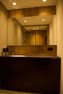 a bathroom with a sink and a large mirror at Ralio apartamentai in Vilnius