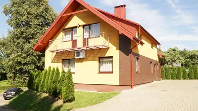 a yellow house with a red roof at Suraučių Svečių Namai in Aukštadvaris