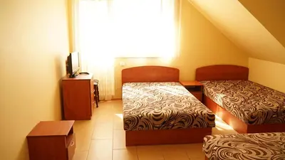 a small room with two beds and a television at Suraučių Svečių Namai in Aukštadvaris