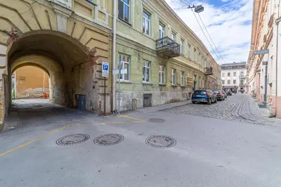 a building with an archway and cars parked on a street at Jazz Old Town apartment with AC in Kaunas