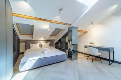 a bedroom with a bed and a desk and a chair at Serenade Old Town apartment with AC in Kaunas