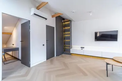a living room with a table and a tv on a wall at Serenade Old Town apartment with AC in Kaunas