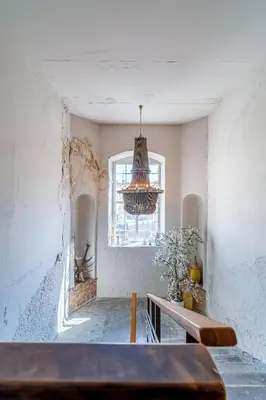 a room with a table and a window and a chandelier at Serenade Old Town apartment with AC in Kaunas