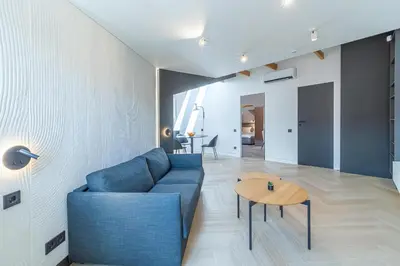 a living room with a blue couch and a table at Serenade Old Town apartment with AC in Kaunas