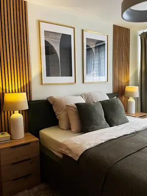 a bedroom with a bed with two lamps and two pictures at Moss Suite in Druskininkai