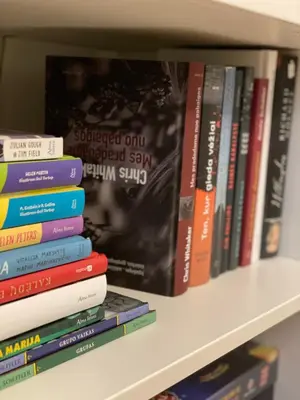 a stack of books sitting on a shelf at Moss Suite in Druskininkai