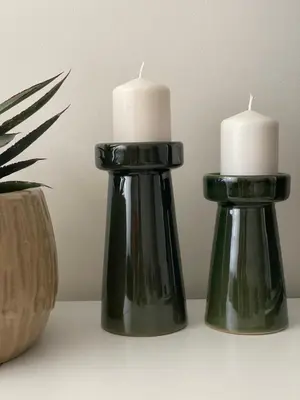 two black candle holders with white candles in them at Moss Suite in Druskininkai