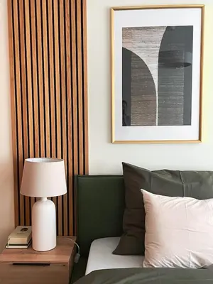 a bedroom with a bed and a table with a lamp at Moss Suite in Druskininkai