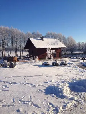 a barn covered in snow with footprints in the snow at Vila Viesai in Trakai