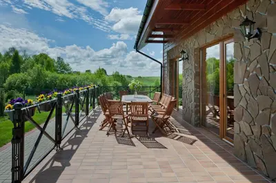 a patio with a table and chairs on a balcony at Vila Viesai in Trakai