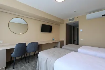 a hotel room with two beds and a mirror at Suncity Hotel & SPA in Šiauliai